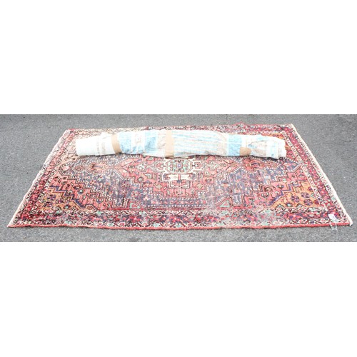 219A - Roll of colourful upholstery material, approx 150cm wide, and woollen hand tied red ground rug appro... 