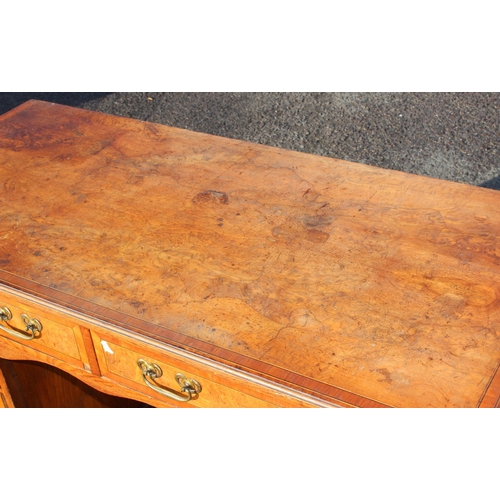 129 - A vintage burrwood and crossbanded 8 drawer desk, approx 122cm wide x 56cm deep x 77cm tall