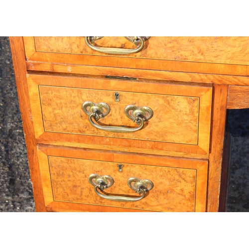 129 - A vintage burrwood and crossbanded 8 drawer desk, approx 122cm wide x 56cm deep x 77cm tall