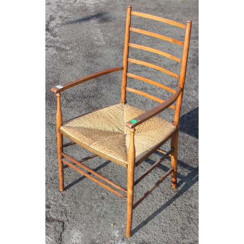 137 - In the manner of Liberty of London, an Arts & Crafts period oak ladder back armchair with rush seat