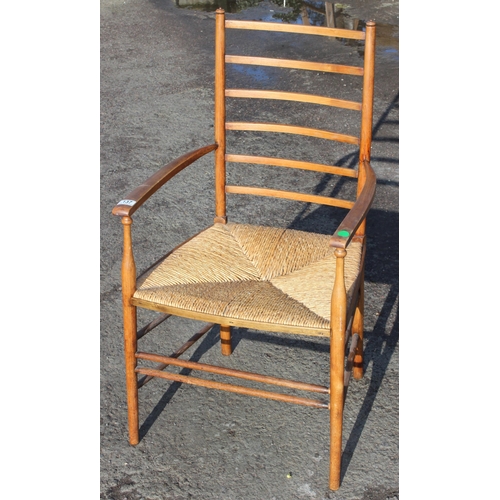 137 - In the manner of Liberty of London, an Arts & Crafts period oak ladder back armchair with rush seat