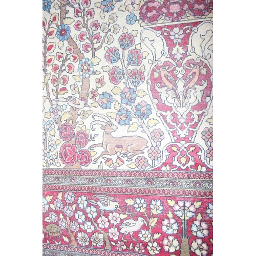 200 - A vintage Persian Sarouk tree of life rug profusely decorated with animals on a red and cream ground... 