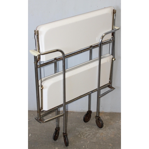 79 - A retro folding white Formica and chrome folding tea trolley, approx 66cm wide x 42cm deep x 71cm ta... 