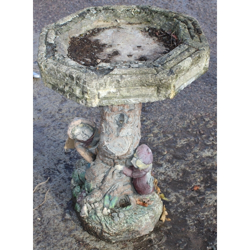 305 - A weathered concrete birdbath with painted figures, approx 40cm wide x 60cm tall