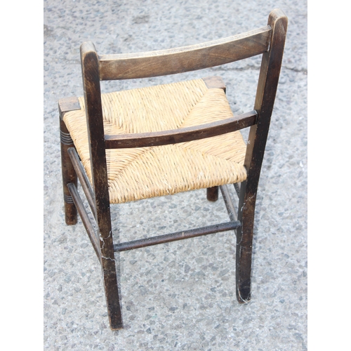 57 - An Arts & Crafts period oak child's chair with rush seat