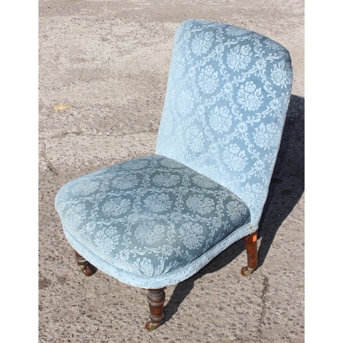 38 - A small antique blue upholstered bedroom chair with turned legs and brass & ceramic castors