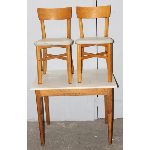 56 - A retro Formica topped table and 2 chairs, the table approx 90cm wide x 60cm deep x 75cm tall