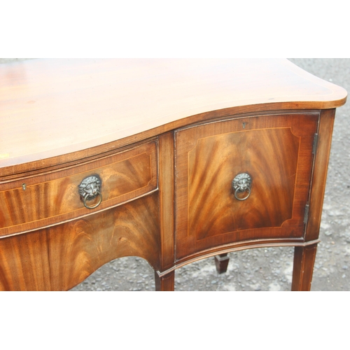 151 - An antique style flame mahogany serpentine sideboard with a central drawer flanked by 2 cupboards, a... 