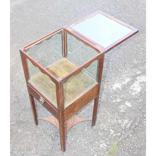 133 - Edwardian mahogany bijouterie table with square glazed hinged lid and single drawer over raised X-st... 