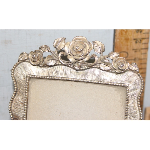 1037 - A pair of silver-plated photo frames with rose decoration, approx 16cm x 10cm