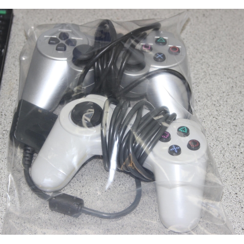 1521 - PlayStation 2 games console with 2 controllers and a remote control, with a selection of games (some... 