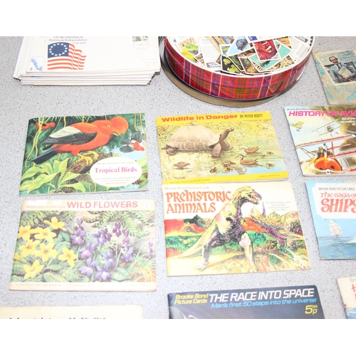 520 - A box of assorted tea cards, loose and in books, and some FDC stamps