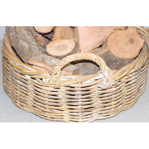 280 - Round wicker basket with handles containing logs, approx 45cm diameter