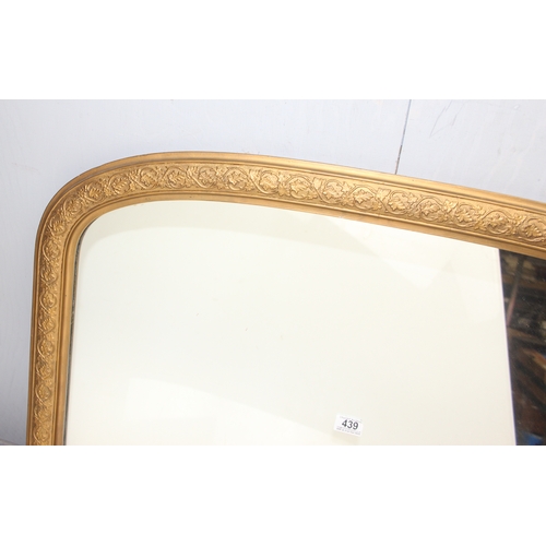 439 - Large over-mantel mirror in gilt frame with leaf motif, wooden panelling verso, approx 103cm x 67cm