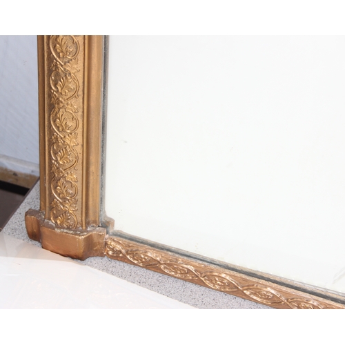 439 - Large over-mantel mirror in gilt frame with leaf motif, wooden panelling verso, approx 103cm x 67cm