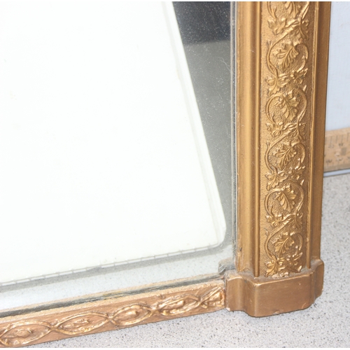 439 - Large over-mantel mirror in gilt frame with leaf motif, wooden panelling verso, approx 103cm x 67cm