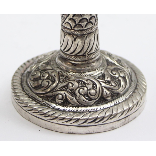 1057 - A small interesting silver pricket style candlestick with embossed decoration, marked silver and XRF... 