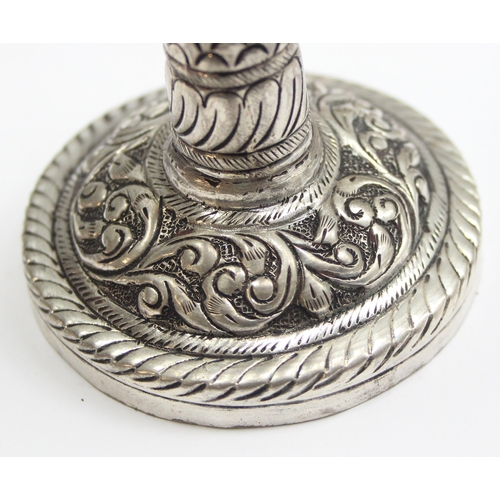 1057 - A small interesting silver pricket style candlestick with embossed decoration, marked silver and XRF... 