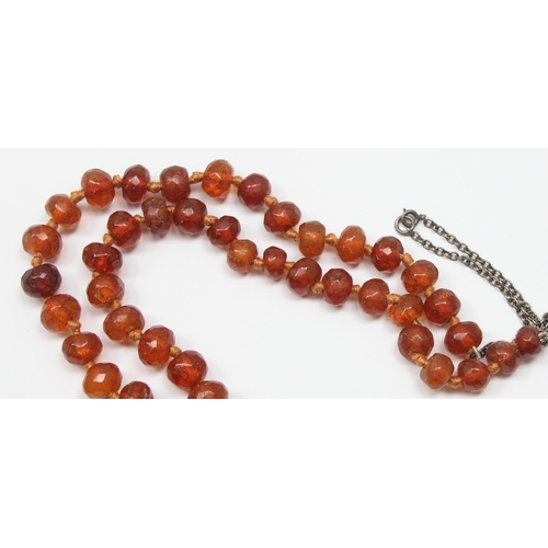 1116 - An unusual vintage silver mounted necklace with facet cut amber coloured beads, each bead showing si... 