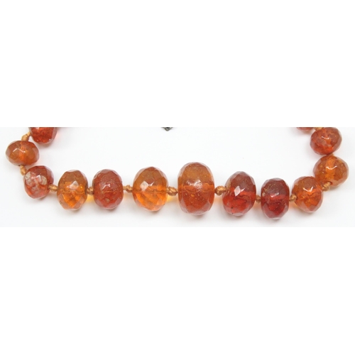 1116 - An unusual vintage silver mounted necklace with facet cut amber coloured beads, each bead showing si... 