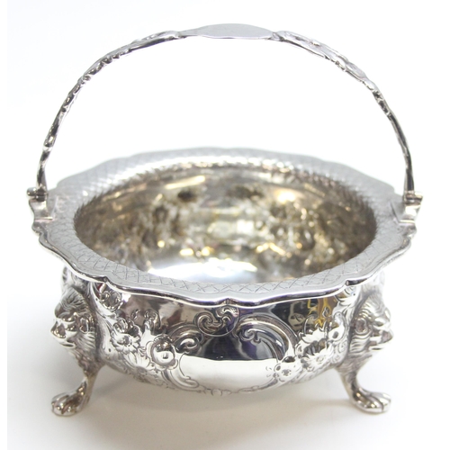 1046 - A George IV period silver basket with swing handle, embossed floral decoration with 3 lion mask and ... 