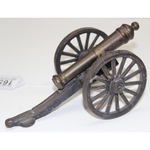 1650 - A miniature vintage brass and iron model of a canon on wheels, approx 20cm wide