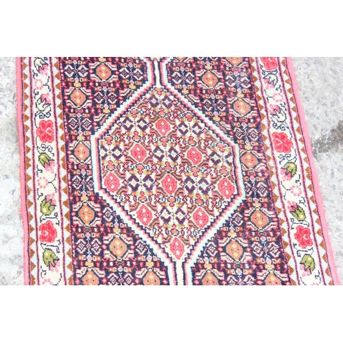 215 - A fine quality Persian Sanandaj runner rug of red and darker ground, fine knot structure, approx 54c... 