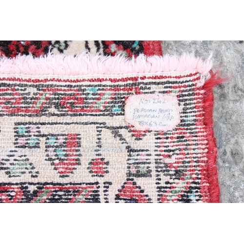 218 - A small red ground Persian Hamadan rug, approx 92cm x 65cm