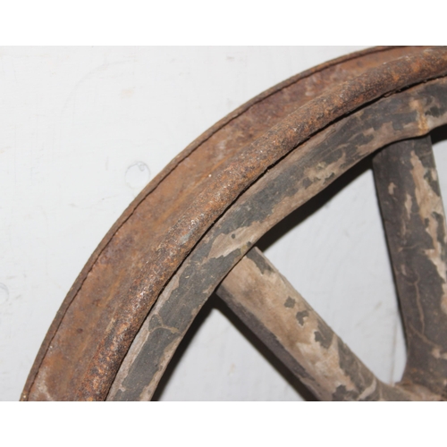 712 - A pair of vintage wooden and iron rimmed early car wheels, unknown vehicle, approx 60cm in diameter