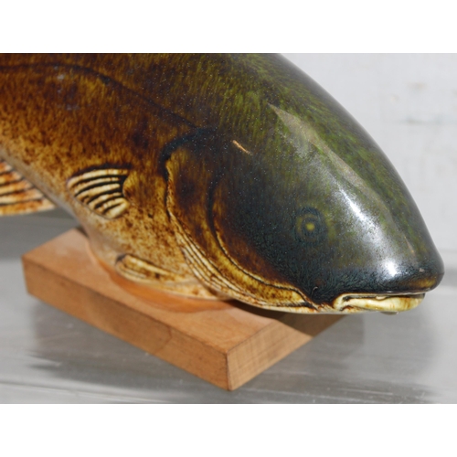 1637 - Sven Wejsfelt for Gustavberg, a ceramic fish on a wooden stand, the stand with printed makers marks,... 