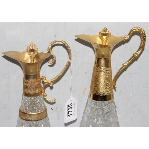 1735 - Matched pair of pressed crystal glass decanters/claret jugs with gold tone detail, largest approx 39... 