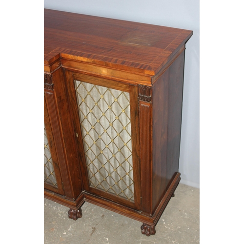 70 - A Regency period rosewood sideboard with lion paw feet and pierced brass grills with curtain backs, ... 