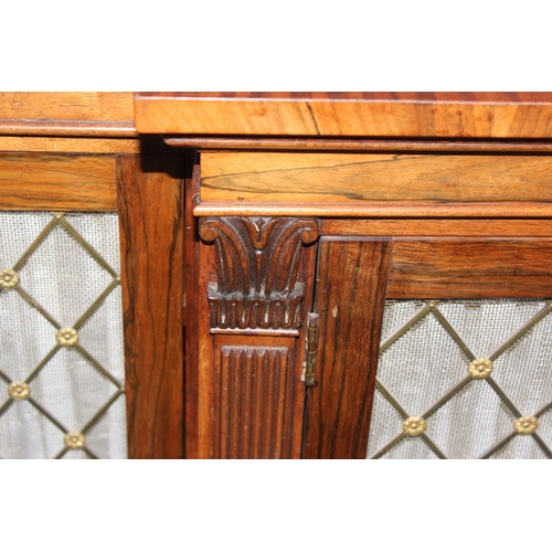 70 - A Regency period rosewood sideboard with lion paw feet and pierced brass grills with curtain backs, ... 