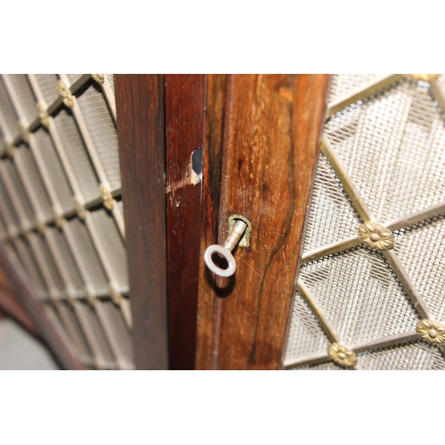 70 - A Regency period rosewood sideboard with lion paw feet and pierced brass grills with curtain backs, ... 