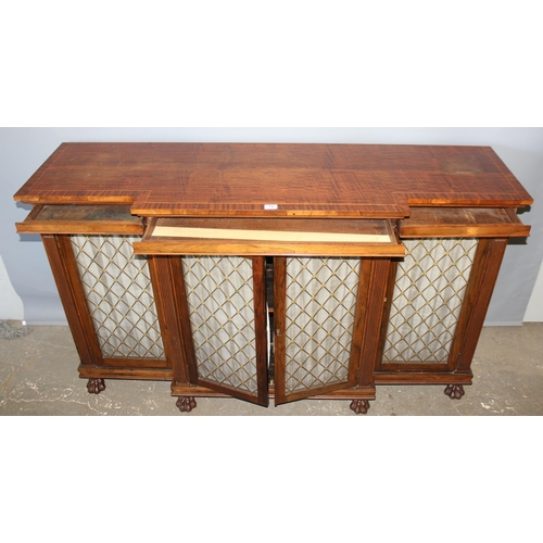 70 - A Regency period rosewood sideboard with lion paw feet and pierced brass grills with curtain backs, ... 