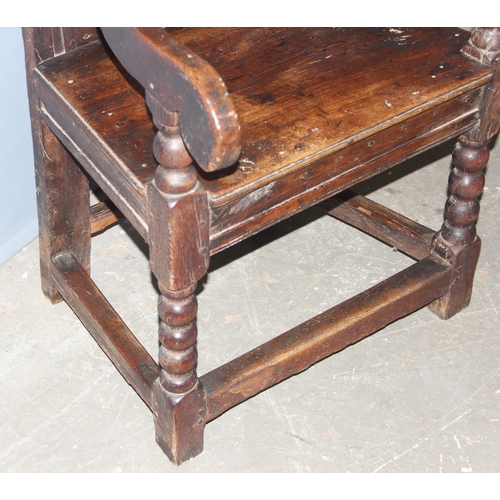 95 - An antique oak Wainscot Elbow Chair with carved and panelled back on turned supports and squared str... 