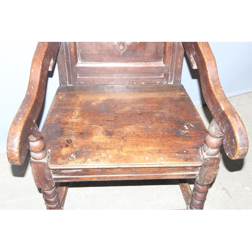 95 - An antique oak Wainscot Elbow Chair with carved and panelled back on turned supports and squared str... 