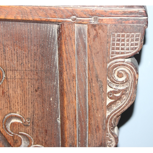 95 - An antique oak Wainscot Elbow Chair with carved and panelled back on turned supports and squared str... 