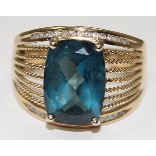 2044 - A retro style 9ct gold cocktail ring set with a large central facet cut blue stone surrounded by 2 r... 