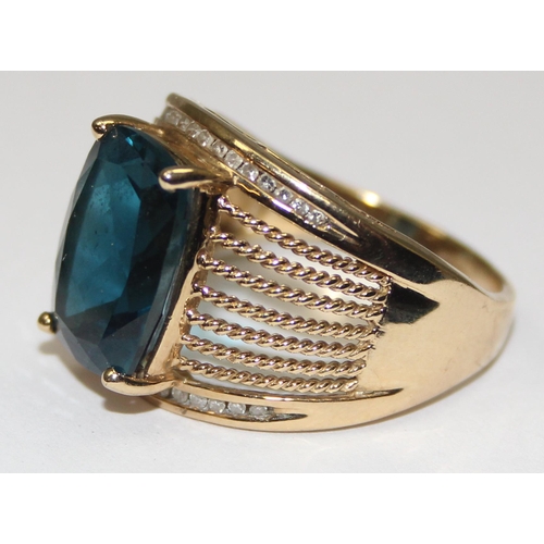 2044 - A retro style 9ct gold cocktail ring set with a large central facet cut blue stone surrounded by 2 r... 