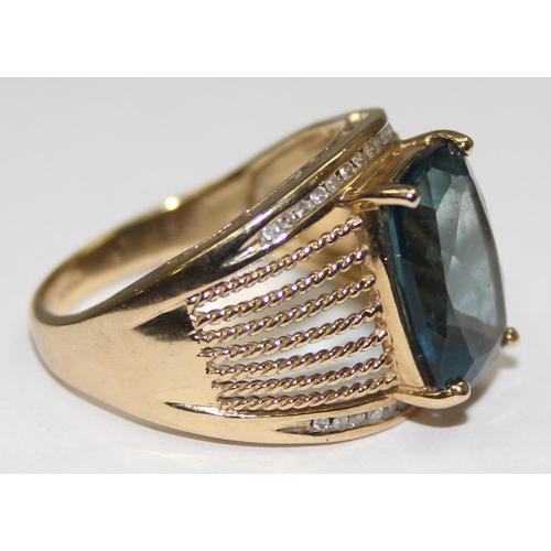 2044 - A retro style 9ct gold cocktail ring set with a large central facet cut blue stone surrounded by 2 r... 