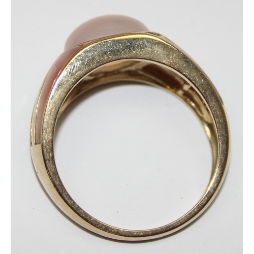 2048 - A retro style 9ct gold cocktail ring set with a cabochon stone, possibly a moonstone with 2 lines of... 