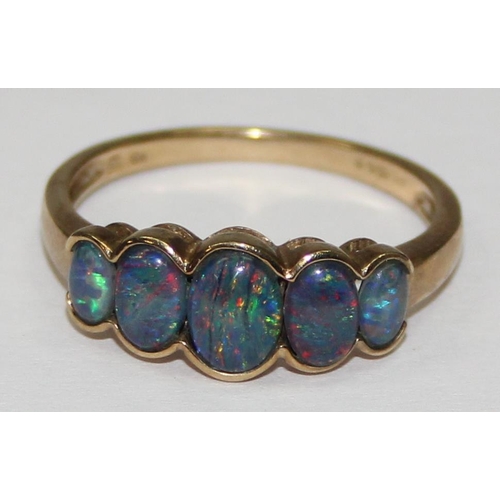 2056 - A 9ct gold ring set with a graduated line of 5 black opal type stones, possibly triplets, full Engli... 