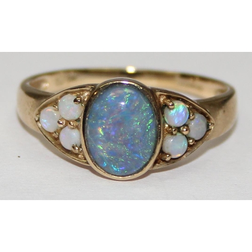 2062 - A 9ct gold oval shaped black opal triplet ring flanked by smaller opals, full English hallmarks, app... 