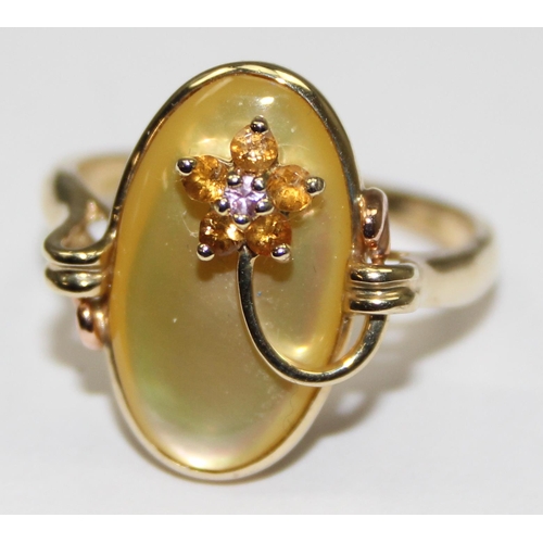 2070 - A retro style 9ct gold dress ring, a coloured oval mother of pearl backing fronted with a small gem ... 