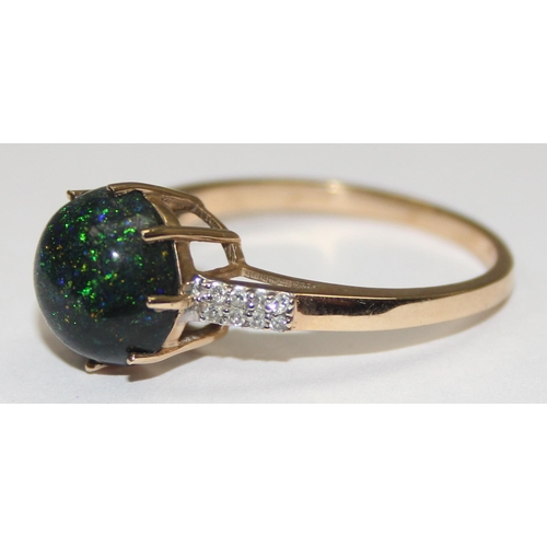 2072 - A retro style 9ct gold dress ring, a round dark cabochon aventurine like stone flanked by small diam... 