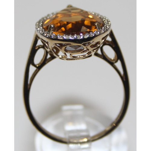 2073 - An antique style 9ct gold dress ring, a facet cut pear shaped citrine surrounded by small diamonds, ... 