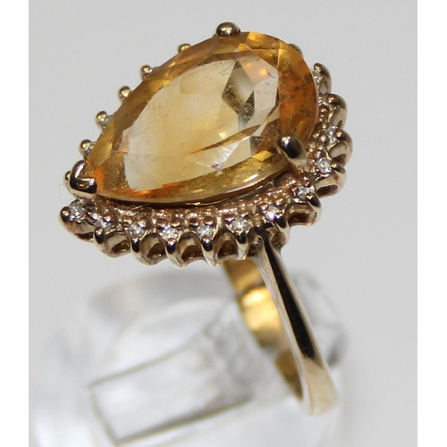 2074 - An antique style 9ct gold dress ring, a facet cut pear shaped citrine surrounded by small diamonds, ... 