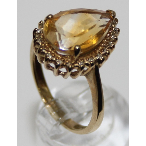 2074 - An antique style 9ct gold dress ring, a facet cut pear shaped citrine surrounded by small diamonds, ... 