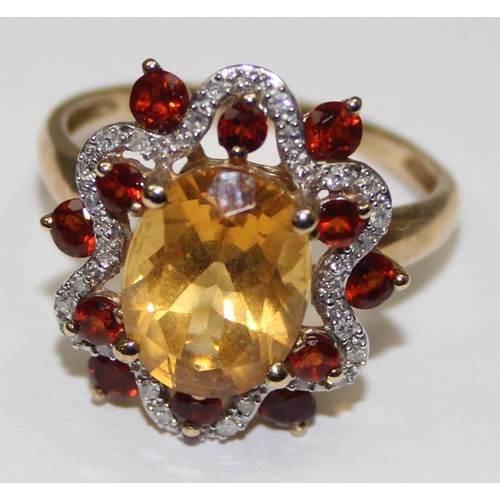 2076 - A retro style 9ct gold citrine dress ring, a large facet cut central stone surrounded by a ribbon of... 